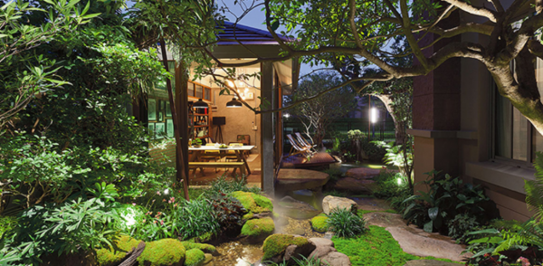 Taman tropis dengan pohon-pohon rindang dan air terjun buatan